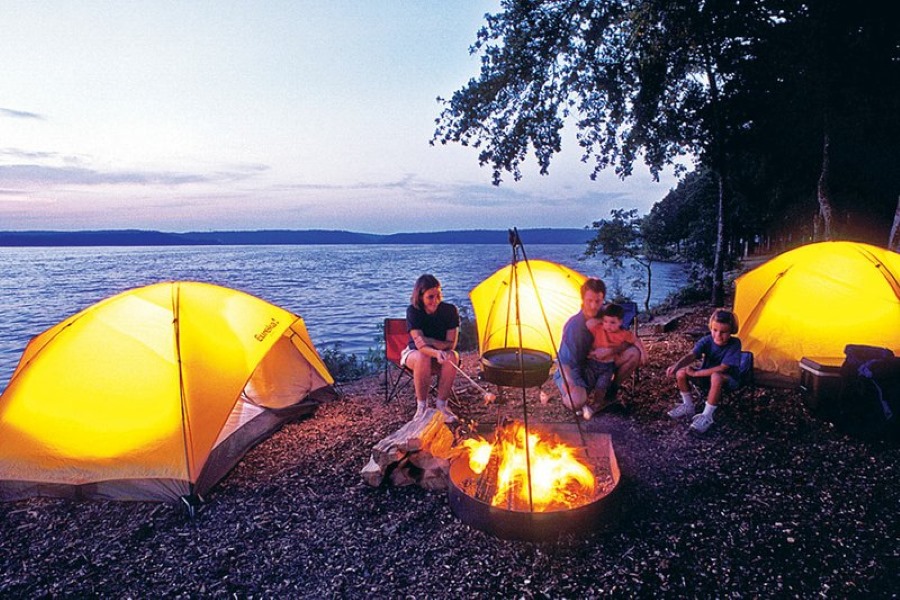 những chiếc lều được chiếu sáng bởi đèn cắm trại bên cạnh lửa trại