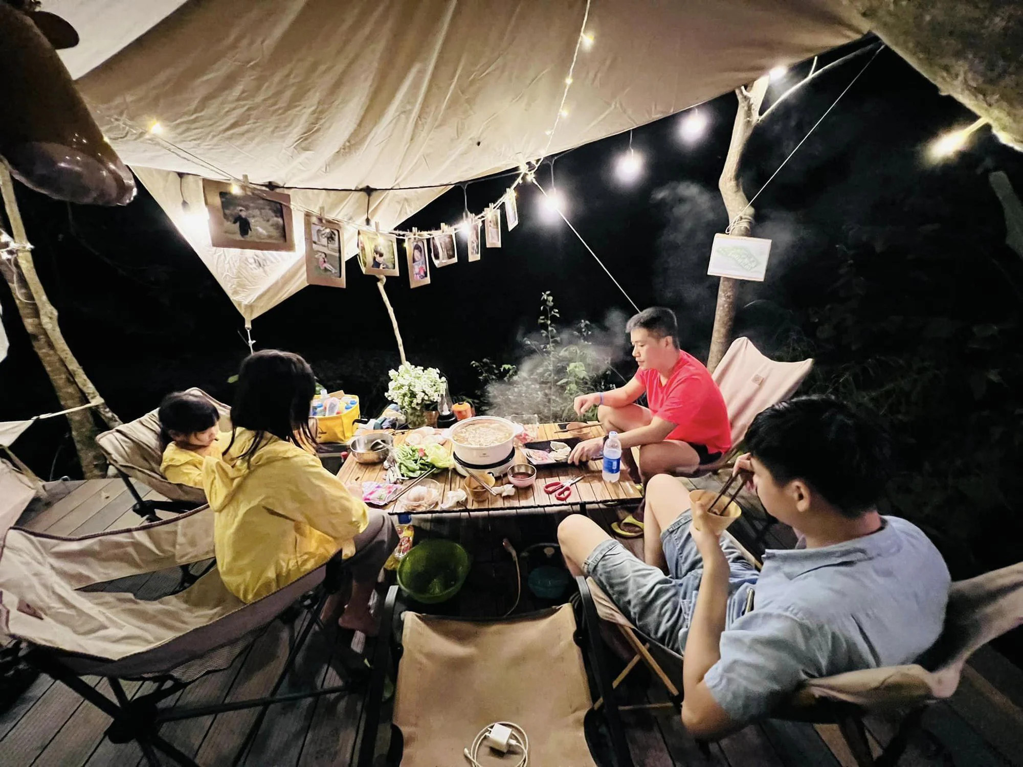 gia định đang cắm trại trong chiếc lều với nhiều đèn cắm trại